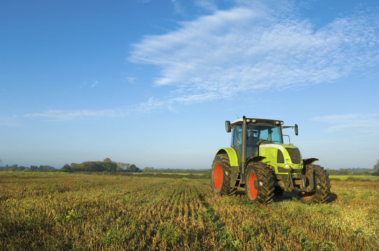 Fototapeta A tractor in a stubble field in Gloucestershire.