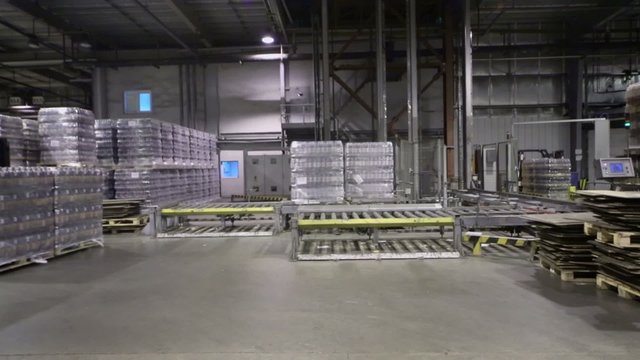 packaged beer bottles in large warehouse and loader machine