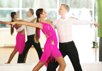 Naklejka premium Beautiful couple in active ballroom dance, indoors