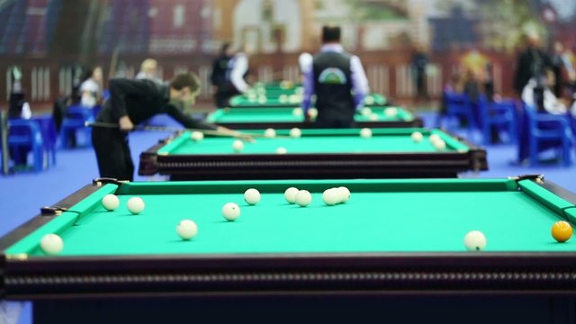 Competitors play billiards at Tournament. Focus on balls