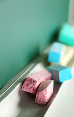 Chalk resting on school board, close up