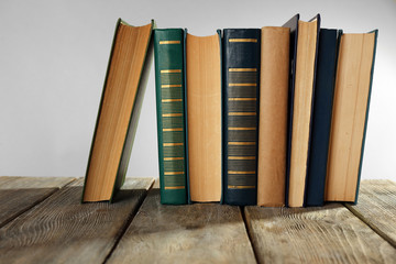 Old books on wooden table on gray background