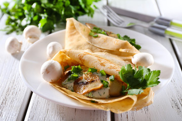 Pancakes with creamy mushrooms and greens in plate