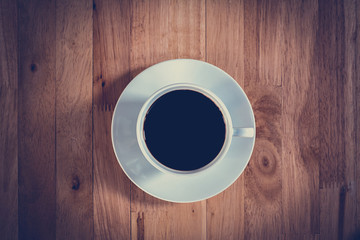 Top view of black coffee in the cup on wooden table 