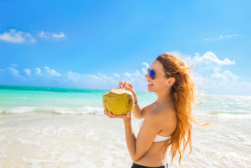 Woman with sunglasses on tropical beach enjoying ocean view