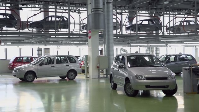 People work on conveyor with new cars Lada Kalina at factory