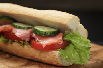 sandwich with salmon and vegetables on slate background