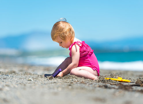 little cute girl playing in the sand