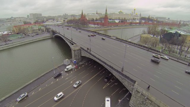Cityscape with cars ride by bridge and quay near Kremlin complex