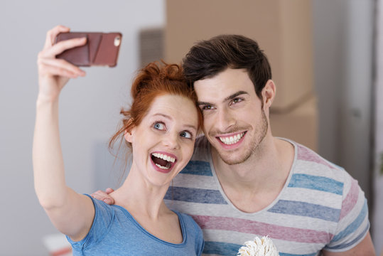 lachendes paar macht ein selfie beim umzug