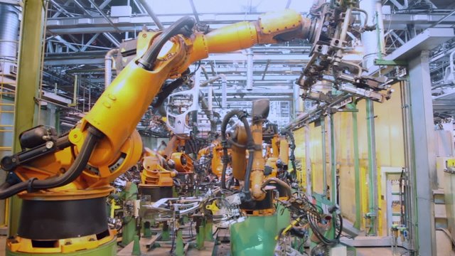 Robotics work in production line of car parts at factory