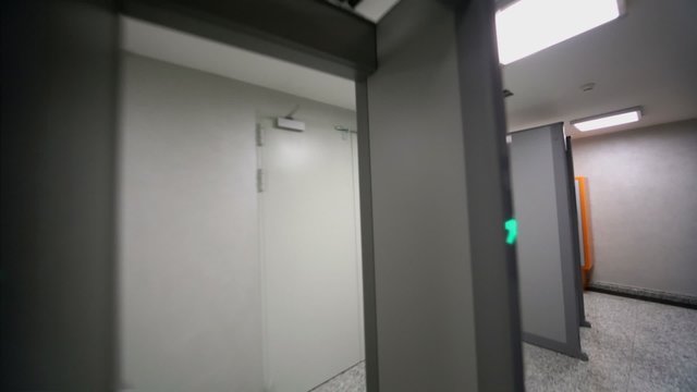 Elevator door opens on floor with security checking frames