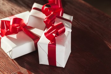 Anniversary. White gift box with red ribbon isolated on red