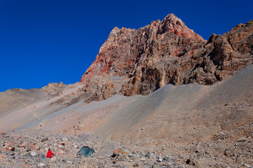 Man next to tent in the mountains.