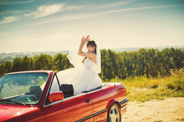 Runaway bride. Beautiful woman on red cabriolet