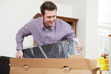 Man Unpacking New Television At Home