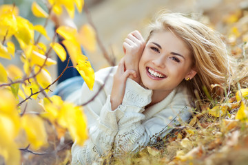 Portrait of beautiful young woman walking outdoors in autumn 
