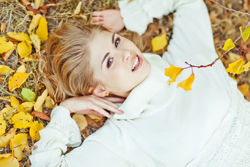 Portrait of beautiful young woman walking outdoors in autumn 