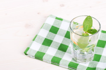 water with lemon and mint in a glass on the table top viewew