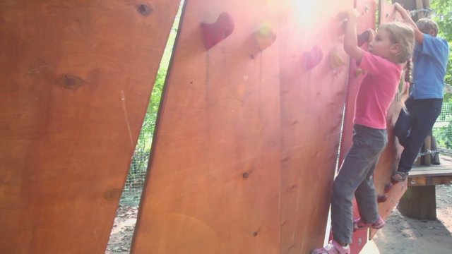 Children creep on pendant wall in outdoor climbing center
