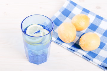 water with lemon and mint in blue glass on the table top view
