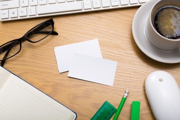 Desk. Blank business cards with supplies and coffee cup on