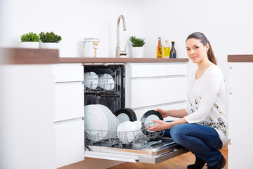 20s woman in kitchen, empty out the dishwasher 3