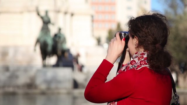 Woman photographs monument to Cervantes at Espana Plaza