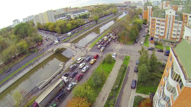 Day traffic on river embankment in cloudy day, above view