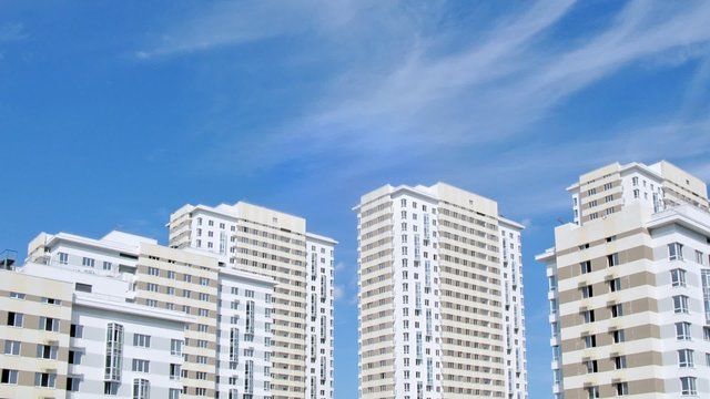 Roofs of housing estate stands against blue sky
