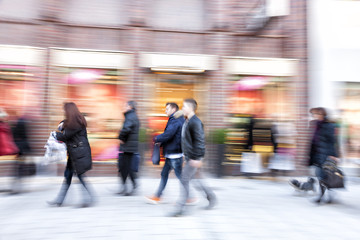 Shopper walking against shop window, zoom effect, motion blur