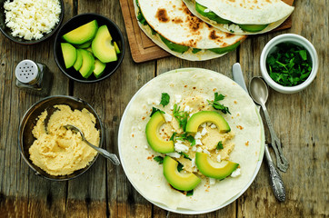 tortilla with hummus, avocado, feta and parsley