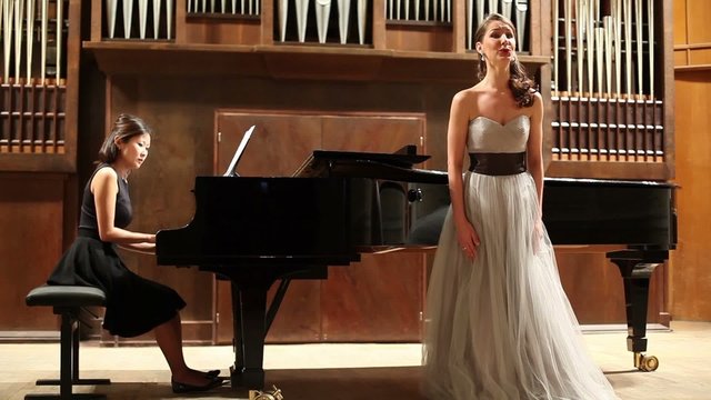 woman pianist and opera singer finishes the performance