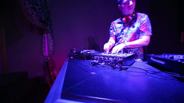 DJ at his workplace in nightclub, camera moves around