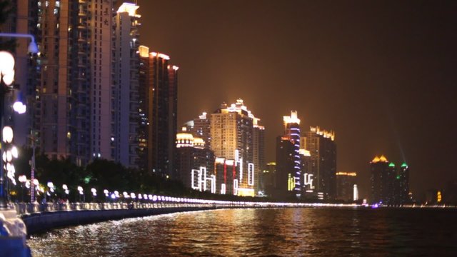 Building with neon lights reflecting in the river at night