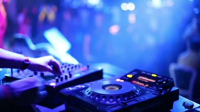 Hands of DJ which mixes music tracks with CD-players