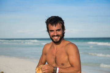 Strong Latin Male Survivor Opening a Coconut.