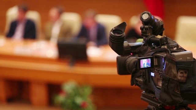 Video camera of cameraman working on press conference 