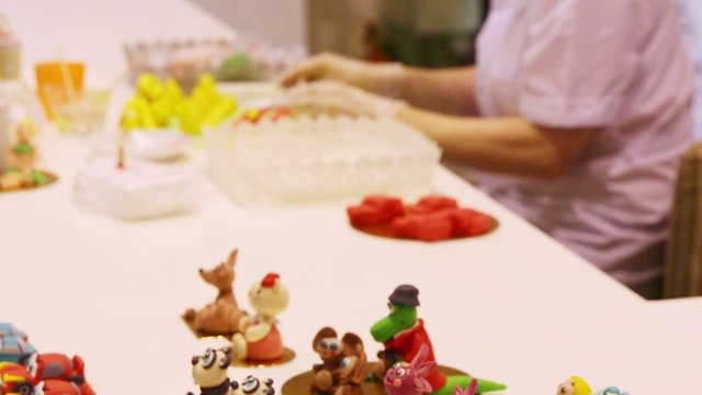 Sweet toys and female hands creating figures in cafe Anderson