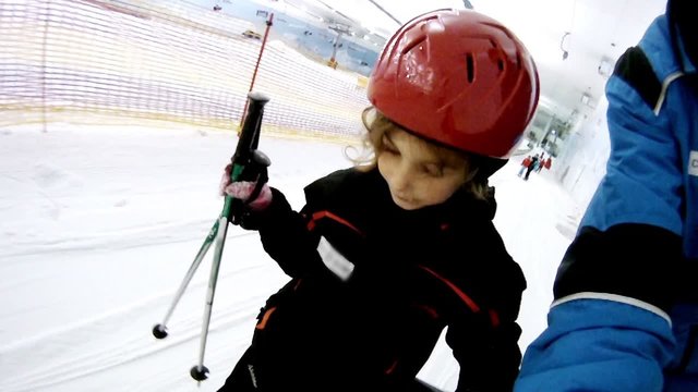 Girl rises on skilift together with father