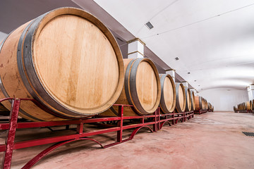 American oak barrels with red wine. Traditional wine cellar