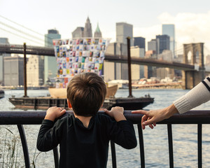 Young boy looking at boat with Manhattan skyline at background