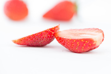 Closed up half of strawberry on white