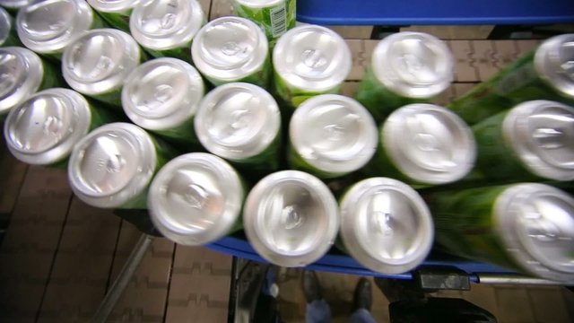 Many empty aluminum cans for drinks move on conveyor