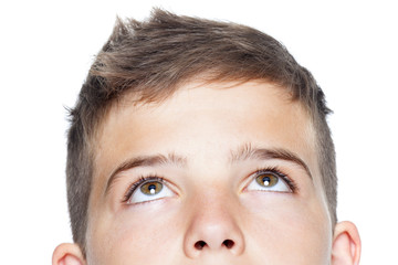 Fototapeta premium Closeup of teenager boy looking up, isolated on white