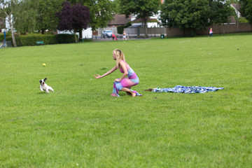 Girl playing with a cheerful dog .