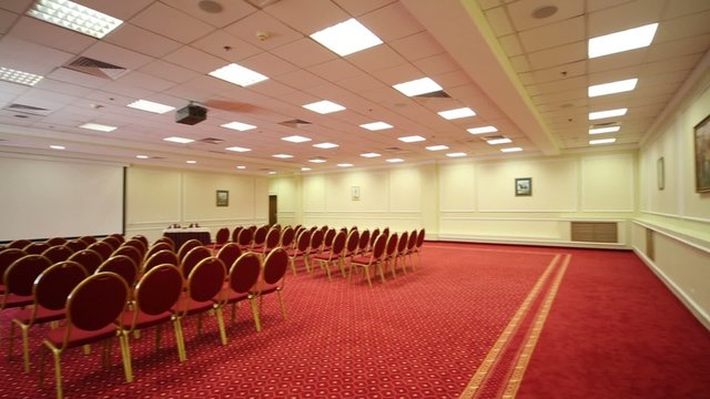 Screen, chairs and projector in empty conference hall