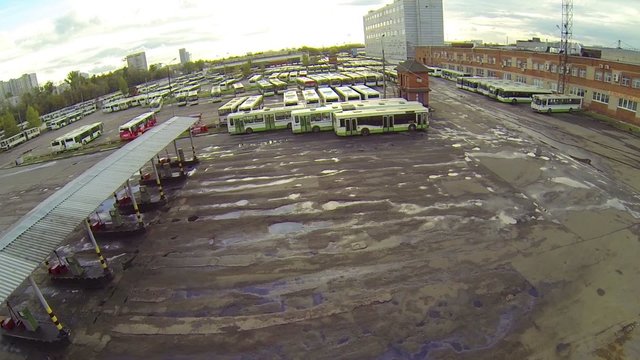 Parking lot with busses and gas station, moving camera