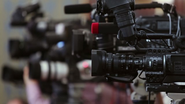 Operators work with equipment in row of few cameras