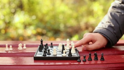 Grandmother and child hands move chessmen on chessboard